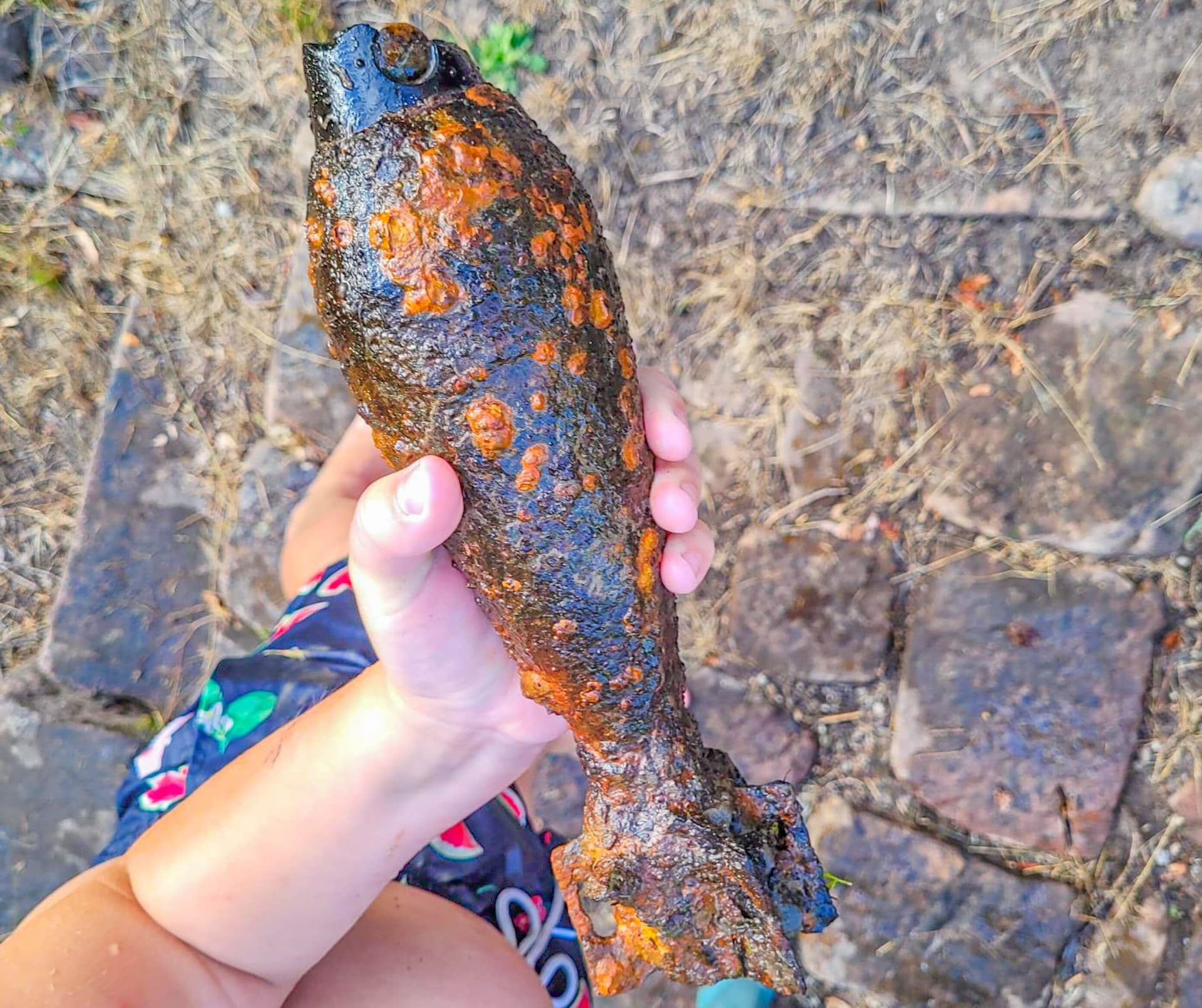 Kinder finden beim Spielen im Fluss Weltkriegs-Wurfgranate